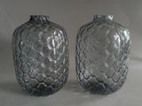 two glass vases sitting next to each other on a table