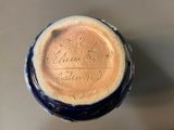 a close up of a blue and white vase with writing on it