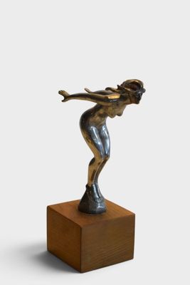 statue of a woman on a wooden base holding a tennis racket