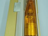 une bouteille de liquide posée dans une boîte sur une table