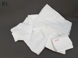 plusieurs serviettes blanches ornées de dentelle posées sur une table