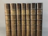 six livres anciens alignés sur une surface blanche