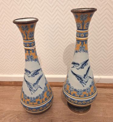 une paire de vases bleus et blancs ornés d'oiseaux, posés sur un plancher en bois