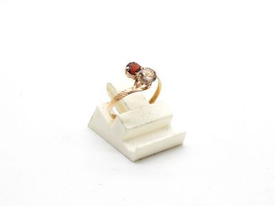 an image of a gold ring with a garnett on top of a stack of books