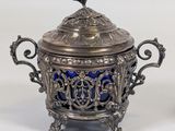an antique silver and blue glass teapot with a bird on top
