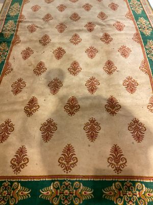 an area rug with a green border and a red and gold border