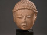 head of a buddha statue on a black stand