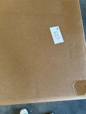 a cardboard box with a sticker on it sitting on the floor