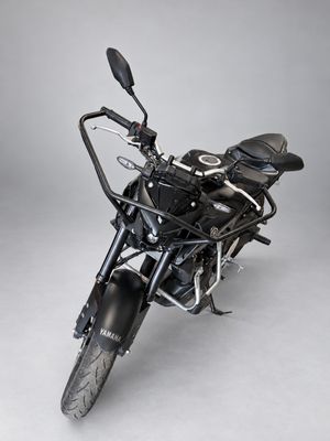 the black motorcycle is parked on the white floor in the studio