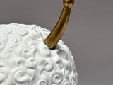 a white figurine with a gold horn sticking out of it ' s head