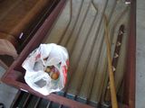 a bag of apples sitting on a bench next to a baseball bat