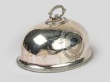 a silver plate with a bell on top of it