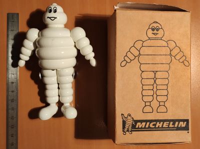 une figurine représentant un homme debout à côté d'un carton