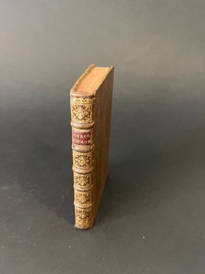an old book sitting on top of a table next to a gray background