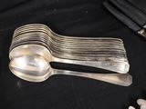 a lot of silver spoons and silverware on a table