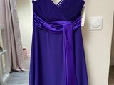 a purple dress hanging on a hanger in a room