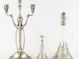 three silver plated candlesticks and a decanter on a white background