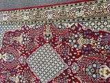 a red rug on the ground with a black cat sitting on it