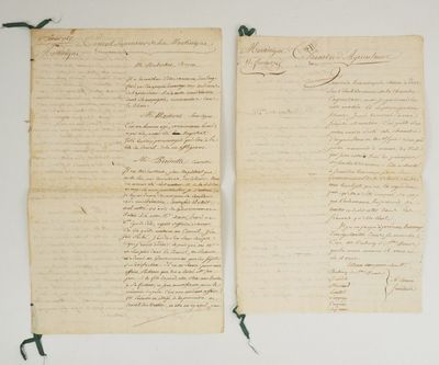 deux vieux papiers sur lesquels il y a des inscriptions, posés sur une table