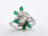 gros plan d'une bague en diamant et émeraude sur fond blanc