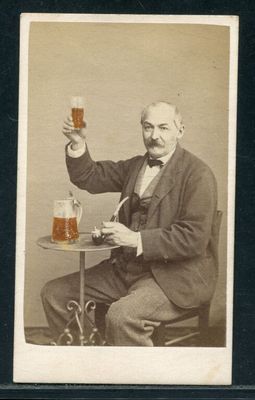 une vieille photo d'un homme tenant un verre de bière