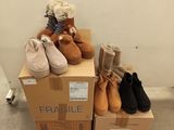 several pairs of shoes are stacked on top of boxes in a room