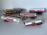 cinq camions miniatures alignés sur une table