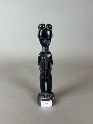 une figurine noire représentant un homme coiffé d'un chapeau