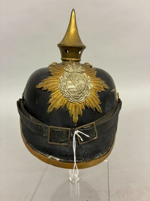 an old helmet with a gold star on it sitting on a clear surface