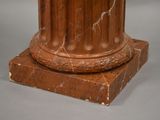 a marble pedestal with a clock on top of it