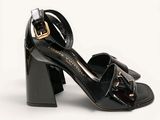an image of a black high heeled shoe with a gold buckle
