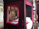 a bed with a red canopy in the middle of a room