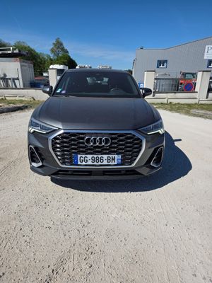l'avant d'une Audi noire garée sur un chemin de terre