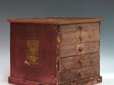 une vieille commode en bois posée sur une table blanche