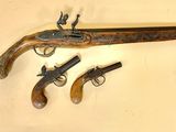 two old guns are displayed on a wall next to each other