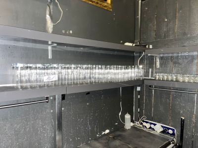 une étagère métallique sur laquelle sont posés plusieurs verres vides