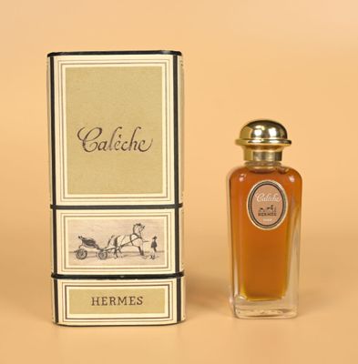 l'image d'un flacon de parfum posé à côté d'une boîte