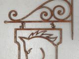une plaque métallique représentant un cheval, accrochée au mur