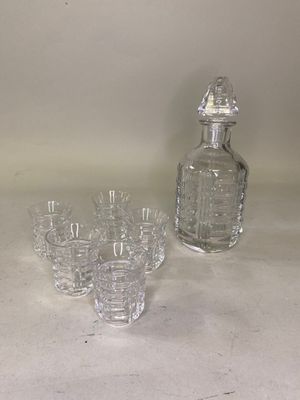 une carafe en verre et des verres posés sur une table