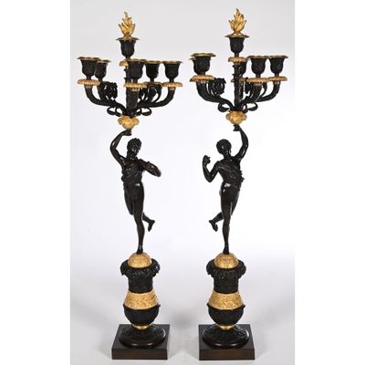 a pair of black and gold candelabs with figures