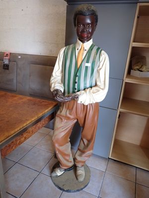 une statue représentant un homme tenant une assiette de nourriture dans une cuisine