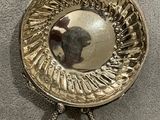 a silver plate with a reflection of a person in it