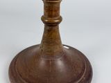 a small globe on a wooden stand on a white surface