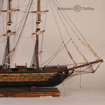 une maquette de bateau exposée sur une surface blanche