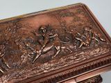 a bronze box with a picture of a man and a woman on horseback