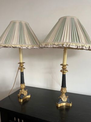 pair of black and gold lamps with shades on them on a table