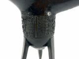a black vase with a design on it on a stand