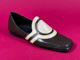 a close up of a pair of black and white shoes on a pink surface