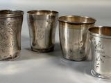 four silver cups sitting on top of a table next to each other