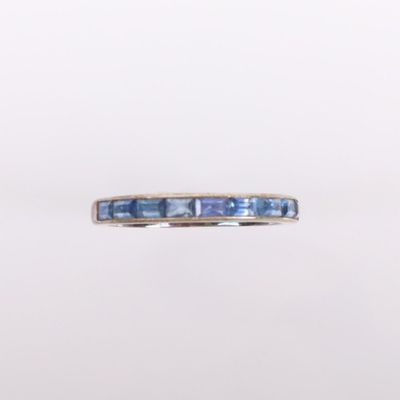 un gros plan d'une bague sertie de saphirs bleus sur fond blanc